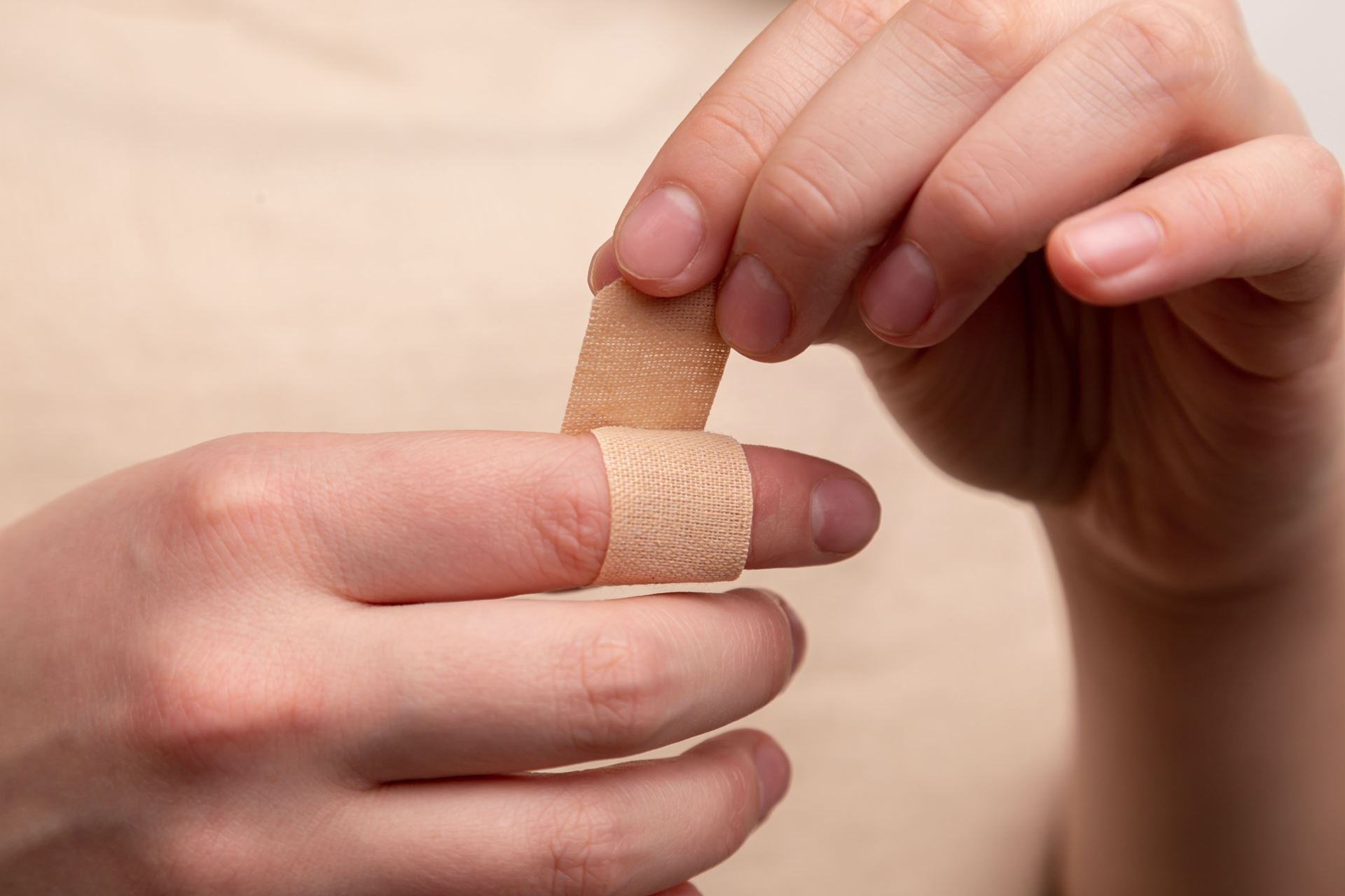 wrapping plaster around index finger. 